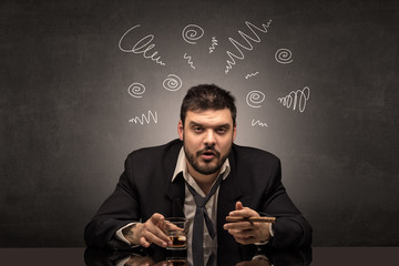 Young drunk man at his office with doodles around
