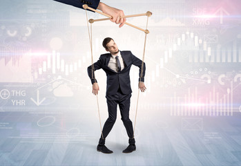 Puppet businessman controlled by another hand with financial concept
