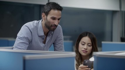 Team Of Young Colleagues Using Phone For Job In Office