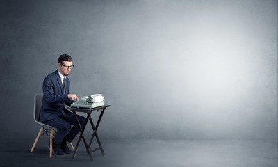 Man working hard on a typewriter in an empty space

