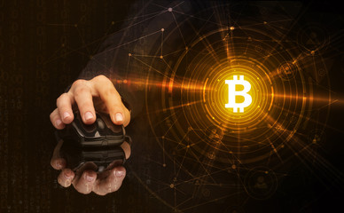 Hand using wireless mouse with cryptocurrency concept on dark background
