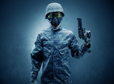 Soldier agent in a dark room with arms on his hand and gas mask
