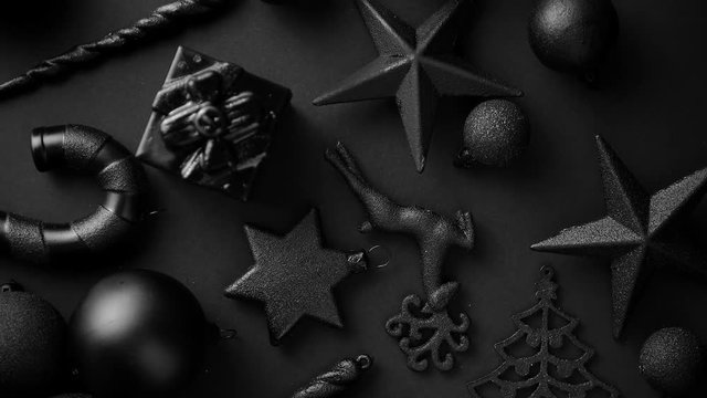 Christmas minimalistic and simple composition in mat black color. Christmas gifts, decorations on black background. Flat lay, top view .