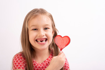 Cute little girl with a heart lollipop