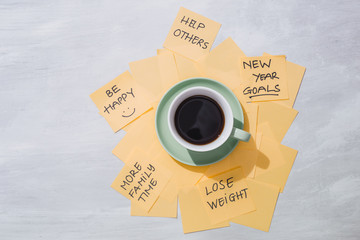 new year goals or resolutions - yellow sticky notes with coffee on table