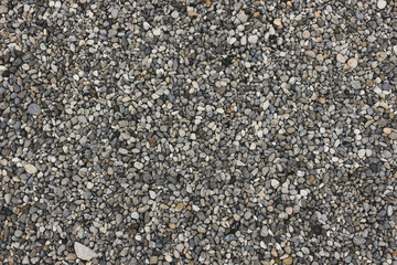 Gray and white natural sand and stones texture of ground. Dotted grey rock floor with place for text
