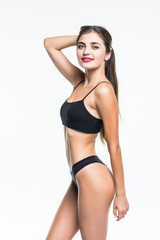 Fototapeta premium Slim tanned woman's body in black lingerie isolated over white background.