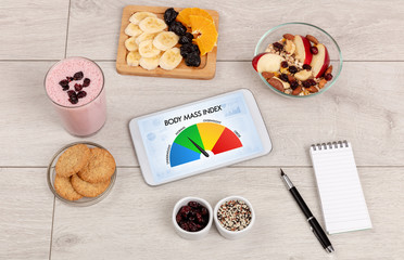 Healthy food with tablet on a wooden background with words Body Mass Index. Health concept.