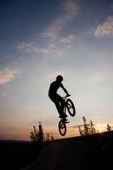 Fototapeta na wymiar Silhouette of man on bike during the jump