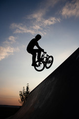 Obraz premium Silhouette of man on bike during the jump