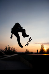 Silhouette of man on skateboard during the jump
