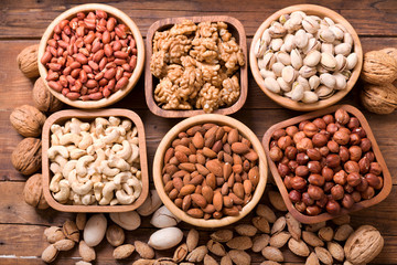 bowls of nuts on wooden table, top view