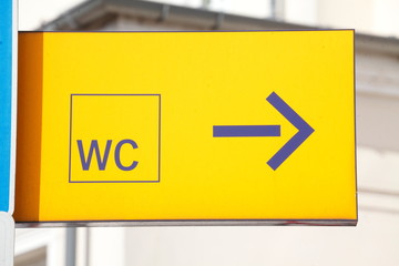Gelbes Toilettenschild WC  mit Pfeil
