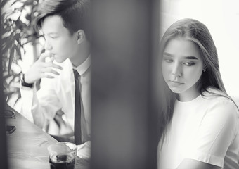Young girl in a cafe. The girl is sitting on the couch and talking on the phone.