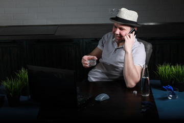 man sitting at table and working on laptop