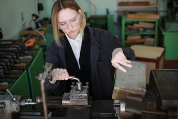 Young woman engineer working at machine tool