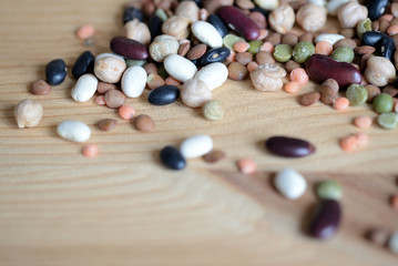 Fototapeta na wymiar Mix of different beans on wooden background close up