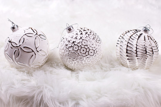  Three white balls on white fur background.
