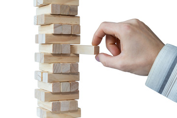 Businessman's hand taking the first block or putting the last block to a sturdy tower of wooden blocks. Concept photo of planning, taking risks and strategizing. Isolated on white background.