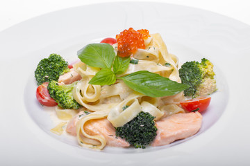 Pasta with salmon, broccoli, tomatoes and red caviar in cream sauce 
