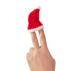 Red hat of Santa claus on the fingers of hand, symbolizing sign of victory isolated on a white background