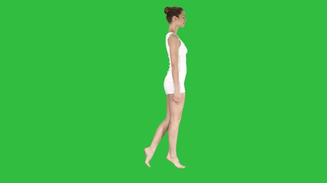 The young woman walking on her tip-toes on a Green Screen, Chroma Key.