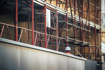 Urban working scene with scaffolding, construction industry work in progress