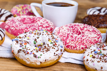 Sweet donuts and cup of coffee on table