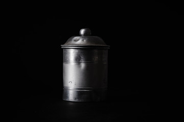 Vintage metallic tin for storing grains or cereals on dark background