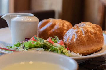 Pie with chicken close up in white plate with salad