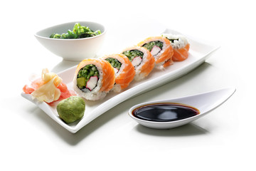Tradycyjne japońskie sushi z łososiem podane na talerzu z sosem sojowym i zieloną sałatką z trawy morskiej - obrazy, fototapety, plakaty