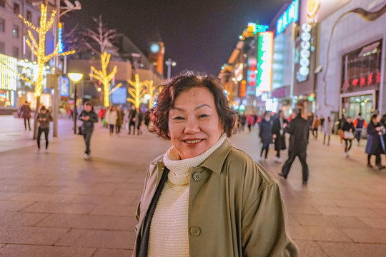 Portrait photo asian women traveler Smile and standing on wangfujing the famous walking Street in beijing the capital of china