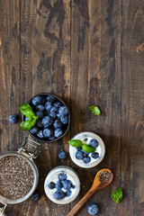 Homemade yogurt with sesena chia and blueberries that have a dark background. Proper nutrition.