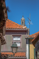 View at a traditional urban buildings on Porto downtown, blurred Clerigos tower on background
