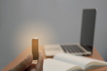 business male hand holding dry battery search notebook and laptop or computer for energy idea creative concept