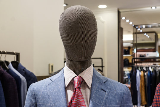 mannequin in a blue suit and white shirt and a red tie