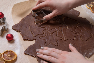 Cutting Christmas cookies, baking gingerbread men, making christmas cookie , homemade traditional  dessert.