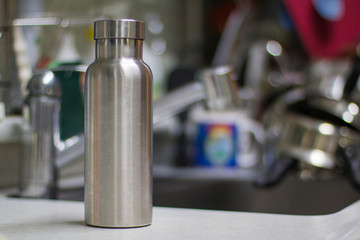 Insulated Stainless Bottle with utensils and sink kitchen background