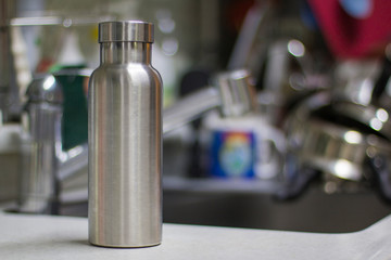 Insulated Stainless Bottle with utensils and sink kitchen background