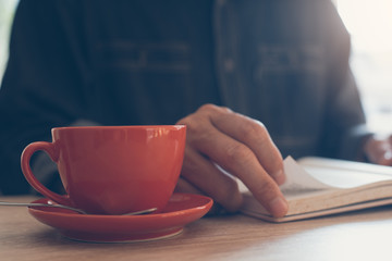 Man reading book drinking coffee