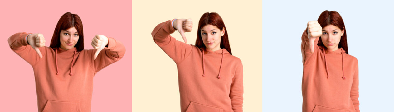 Set of Young redhead girl with pink sweatshirt showing thumb down sign with negative expression. Sad expression on colorful background