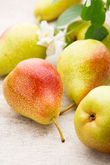 Fresh pears with leaves in a on wooden background.