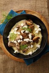 Polenta with cheese in black bowl above