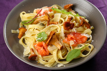 Tasty pasta with salmon and chanterelles mushrooms