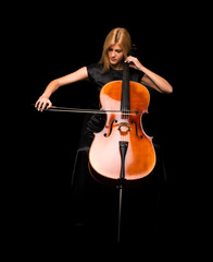 Young girl playing the cello on isolated black background