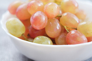 Grapes in a porcelain plate. Ripe pink Muscat grapes.