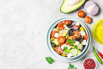Avocado feta Greek salad in a bowl. Top view, space for text.