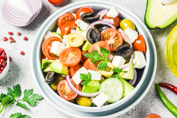Avocado feta Greek salad in a bowl. Top view, space for text.