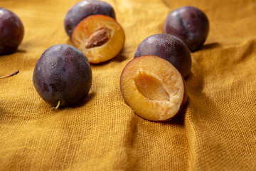 Fototapeta premium Organic plums on linen background