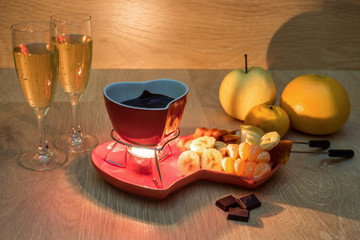 Chocolate fondue with fruit and champagne. Romantic dinner. Love